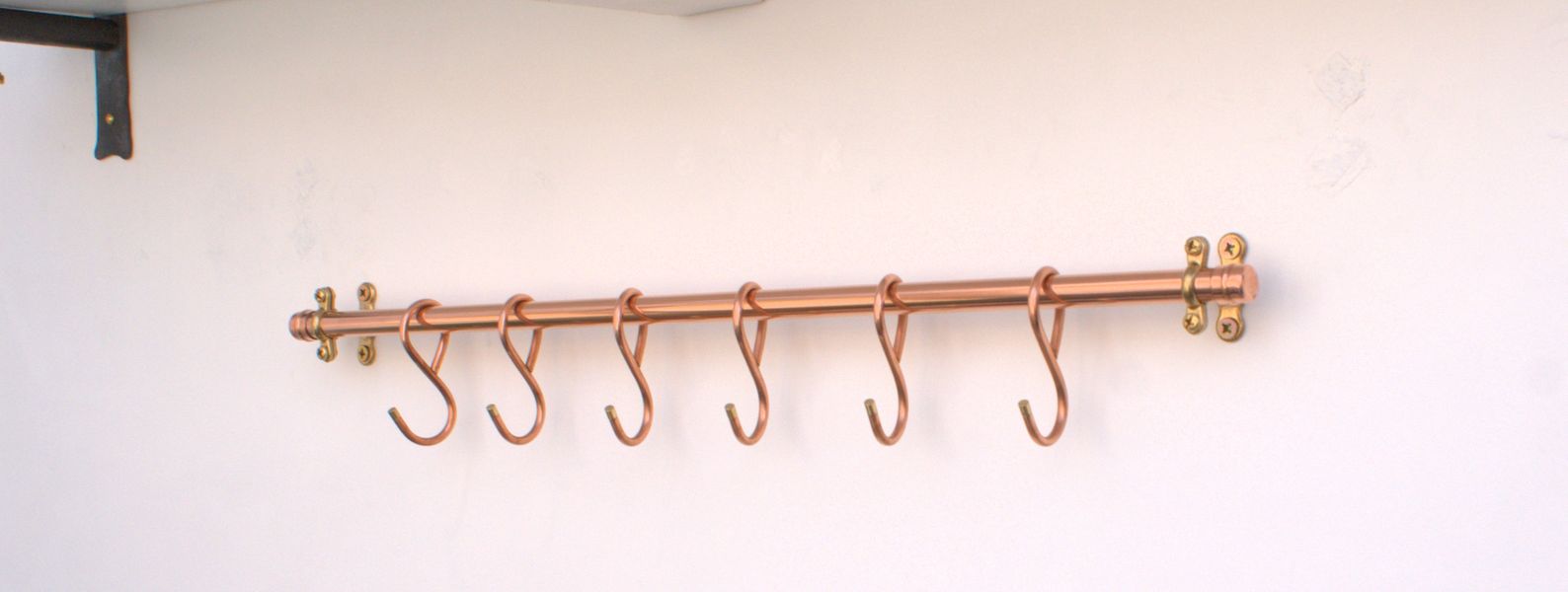 French farmhouse copper pan rack with traditional forged detailing