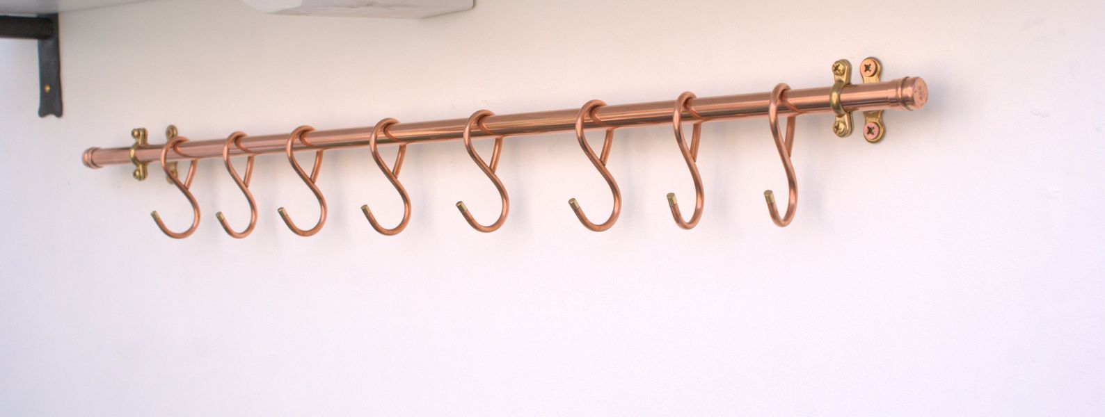 Close-up of hand-forged French hooks on copper pot rack