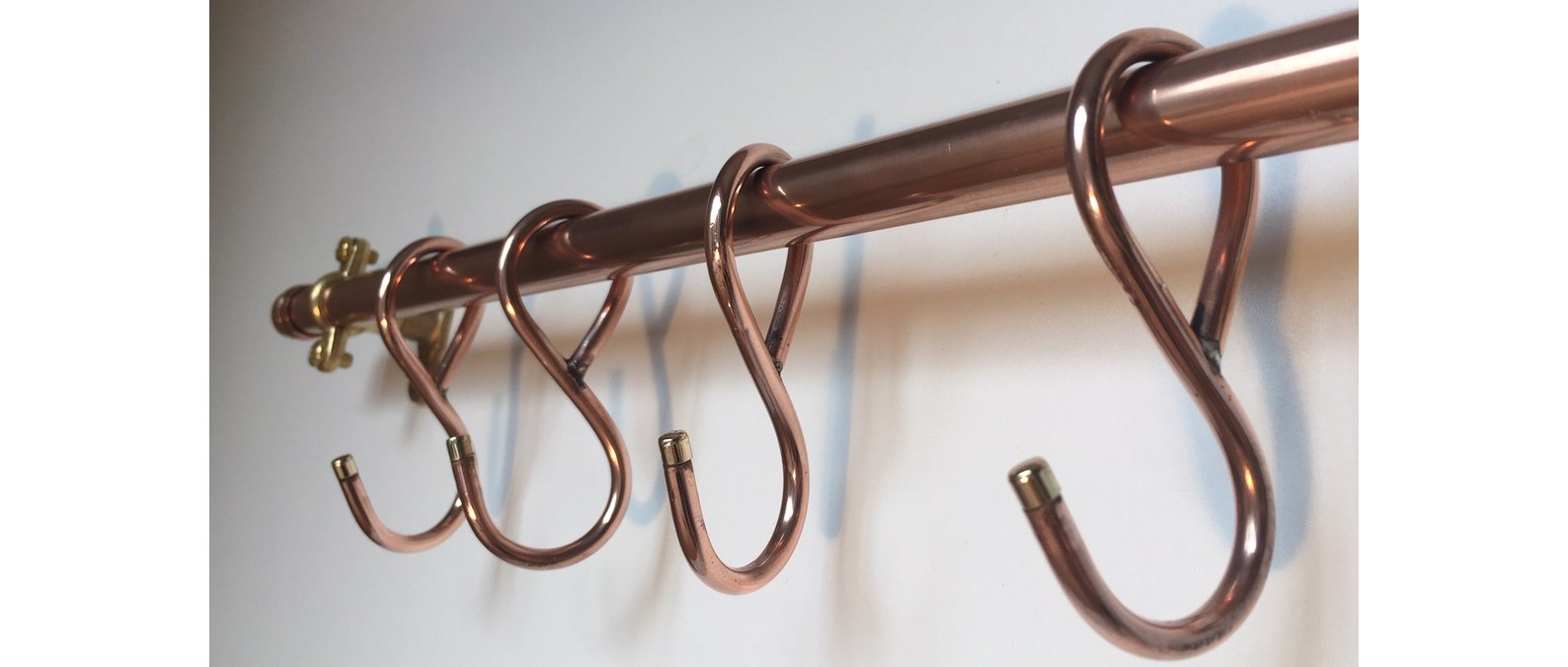 A 36-inch copper pan rack with 10 hand-forged butcher hooks – French farmhouse style